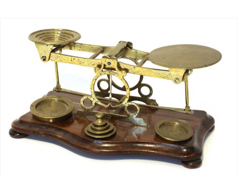 A set of brass postal scales, mid-19th century, possibly 'S Mordan &amp; Co.', the serpentine walnut base supporting six weig