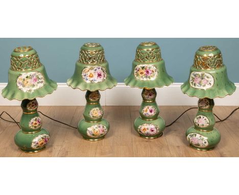 A group of four similar, green-glazed flower decorated table lamps with pierced ceramic shades (each 54cm high)Minor wear to 