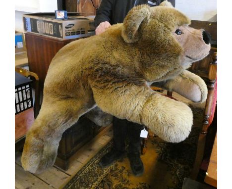 A very large Steiff recumbent teddy bear, with long brown plush, brown eyes, short plush nose and paws, ear button and label,