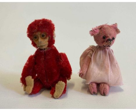 Two miniature Schuco animals, comprising a red monkey compact with internal mirror and puff, and a pink bar in a white dress,