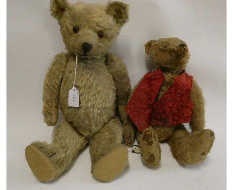 Two old straw filled teddies, comprising a 20" vintage English bear with shaven muzzle, amber eyes and yellow plush, and a 16