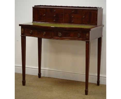 Regency style mahogany serpentine fronted lady's writing table, raised back with six trinket drawers flanked by two cupboards