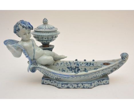 An interesting Dutch Delft inkwell, possibly 19th century,  formed as seated cherub in a boat, painted cockerel mark and ES i