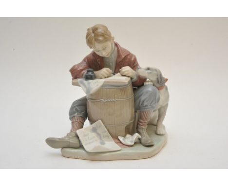 A Lladro figure of a boy sat at a desk