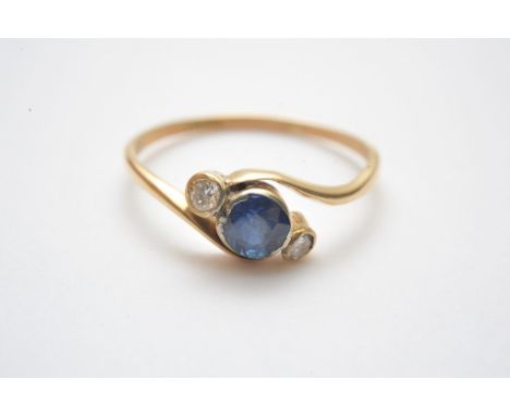 A vintage 18ct gold ring inset with a good colour blue sapphire, flanked by diamonds 