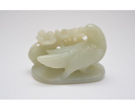 A Chinese green jade carving in the form of a bird and foliage