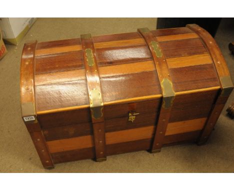 A satinwood and teak trunk with domed lid and brass bound corner