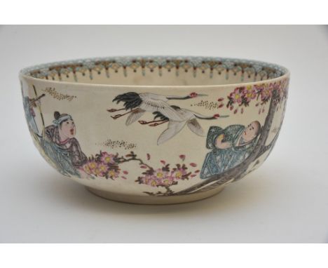 A Japanese Satsuma pottery bowl enamelled with figures hunting storks