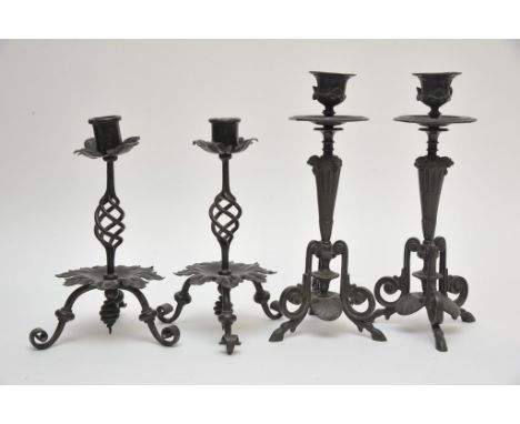 A pair of Regency style bronze candlesticks together with a pair of wrought iron candlesticks