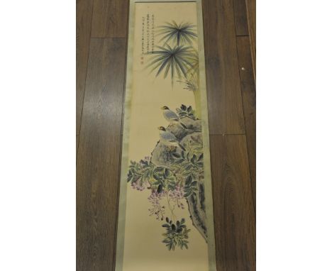 A hand painted Chinese paper hanging scroll depicting birds, flowers and foliage