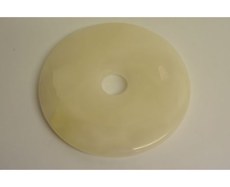 A large Chinese polished white hard stone Bi disc, possibly jade