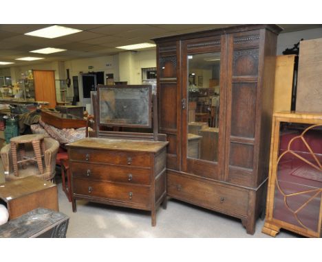 An oak wardrobe fitted with a single mirrored door above a single drawer with conforming dressing chest