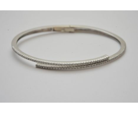 A ladies 14ct white gold bangle set with approximately 0.50ct of diamonds