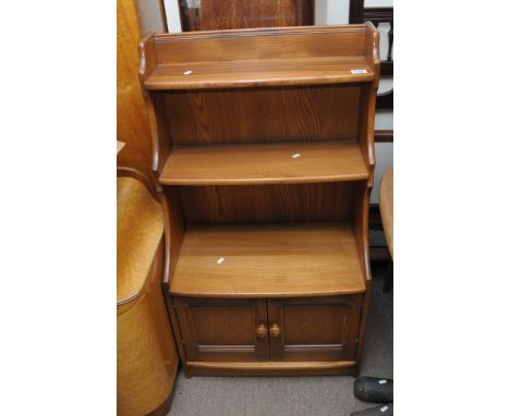 An Ercol light elm waterfall book case