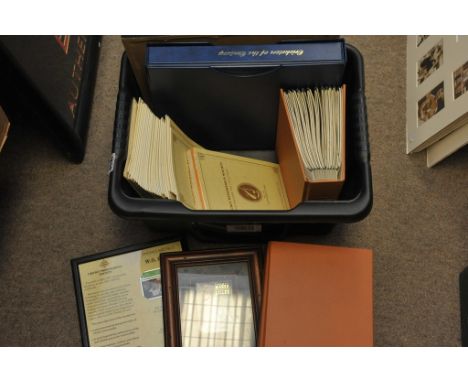 A box containing a collection of cricket items including First Day Covers and stamps, phone cards, Wisdens magazines, and aut