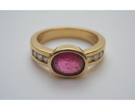 An 18ct gold ring set with large oval cut ruby with diamond set shoulders