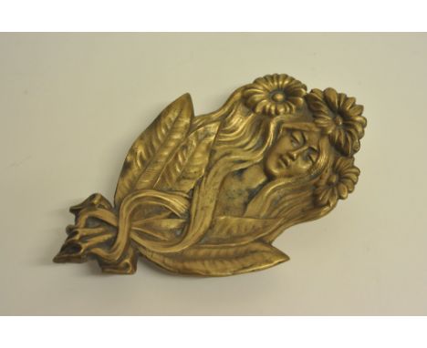An Art Nouveau bronze dish in the form of a female portrait in high relief with sinuous foliate decoration.