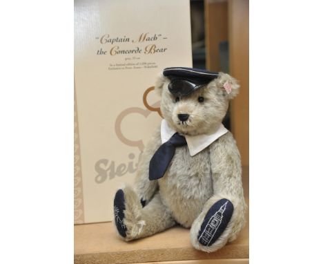 A Steiff Captain Mach the Concorde Bear having grey mohair, wearing Concorde cap and the Statue of Liberty embroidered onto o