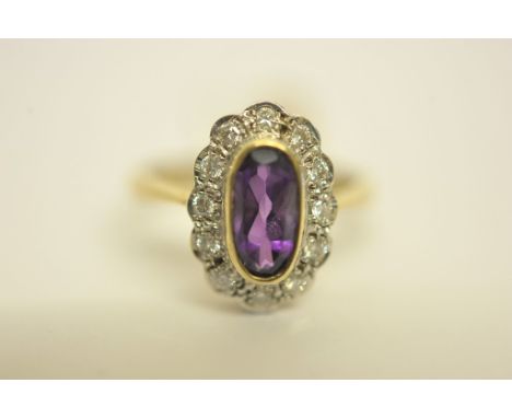 A ladies 9ct gold ring set with central amethyst and diamond surround