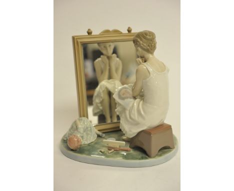 A large Lladro figure of a girl seated by amirror
