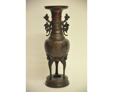 A Japanese bronze vase on three legs with raised decoration of birds, flowers and foliage. Height: 44.5cm approximately