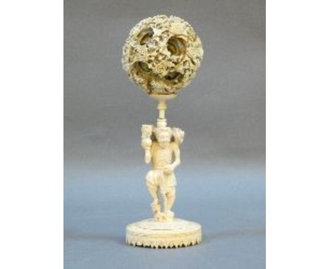 A Chinese ivory puzzle ball, on stand, modelled as an old man with a mask to his face, holding a walking stick, 26cm high