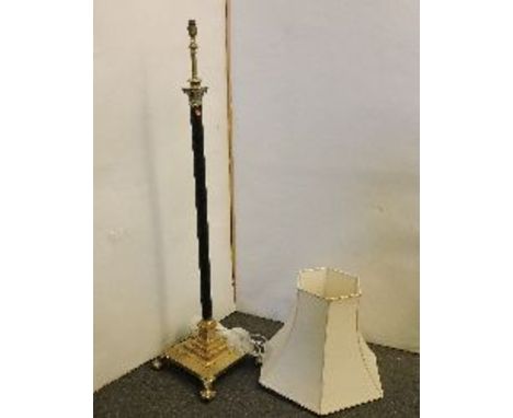 A heavy brass standard lamp, the Corinthian column on a stepped square base and paw feet, with shade
