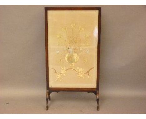 A mahogany framed fire screen, with peacock embroidery
