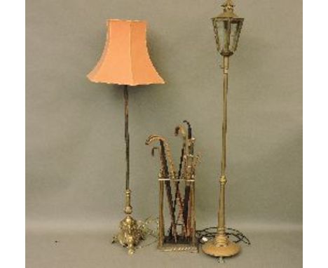 A brass standard lamp, with a lantern light, another standard lamp, a stick stand with various sticks, an agate topped cane, 