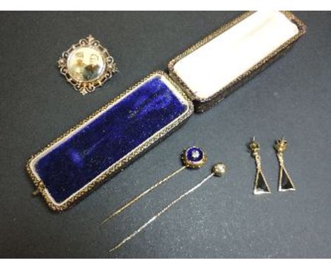 A late Victorian photograph brooch, with an outer gold frame, a gold paste stick pin, a gold cased hammered bead stick pin, a