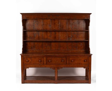 A 19th Century oak Welsh dresser, the closed rack with two shelves above a base with three drawers, on chamfered legs united 