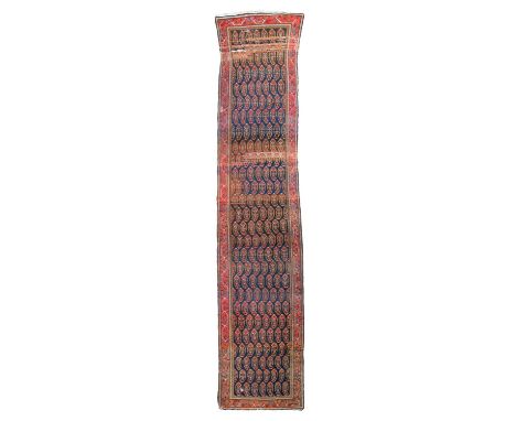 A Malayir runner, West Persia, the abrashed indigo field with an all over design of boteh, framed by a pale cranberry border 