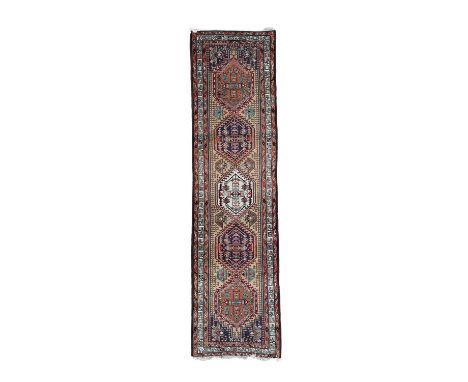 An Erivan runner, South Caucasus, late 20th Century, the camel field of five hexagonal polychrome medallions with aubergine s