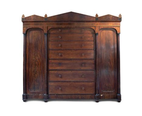 A Regency mahogany compactum or wardrobe, with a triple architectural pediment with anthemion details above a central section