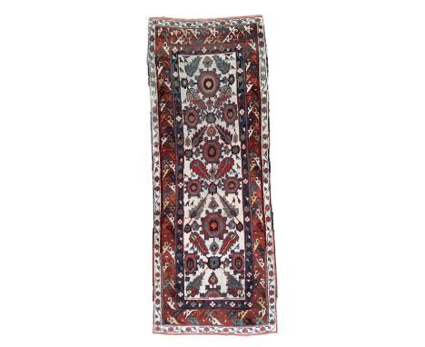 A Karabagh long rug or runner, South Caucasus, second half 19th Century, the ivory field of ornimorphic motifs with a bold de