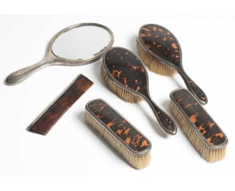 A silver mounted tortoiseshell dressing table set, Stokes &amp; Ireland Ltd., Chester 1923, comprising a hand mirror, a pair 