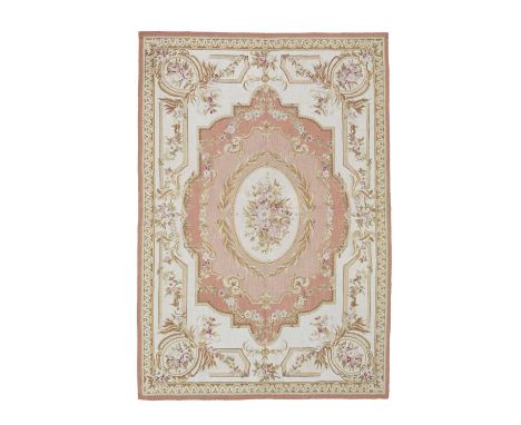 An Aubusson style tapestry, 20th Century, the pale salmon field centred by a floral oval, 216cm x 149cmAll over very good con