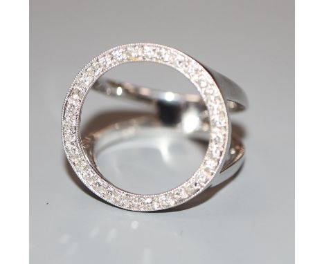 A moder white metal (stamped 750) and diamond set scarf ring, 20mm in diameter, gross 7.8 grams.CONDITION: One stone missing,