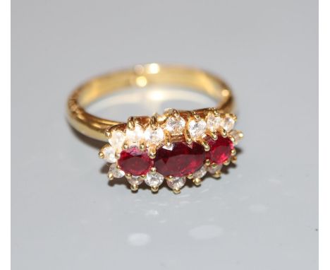 A modern yellow metal, ruby and diamond set triple cluster ring, with expanding shank, size 0-R, gross weight 5 grams.CONDITI