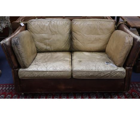 A small vintage two seater Knowle settee upholstered in studded pale brown leather, W.156cm, D.88cm, H.71cmCONDITION: Seat an