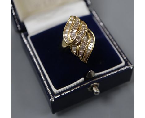 An 18k and trapeze cut diamond cluster set modernist dress ring, size L, gross 8.4 grams.CONDITION: Apart from a few very min