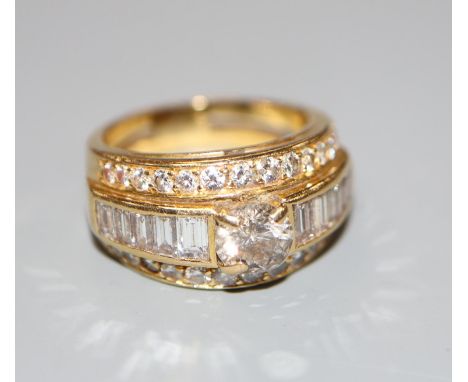 A modern yellow metal and three row diamond set dress ring, size J, gross 7 grams, set with round and baguette cut stones.CON