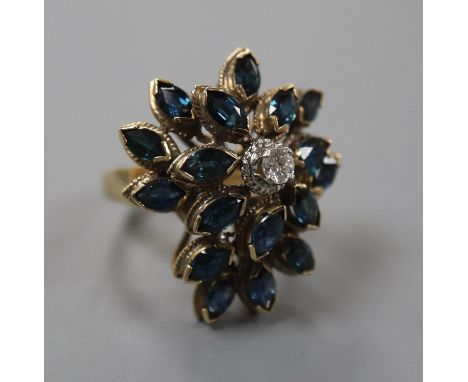 A 14k yellow metal, sapphire and diamond set raised cluster dress ring, of flowerhead design, size M, gross weight 9.2 grams.