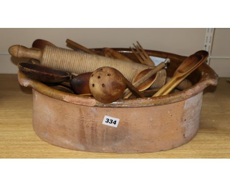A terracotta bowl, a pill roller and a collection of wood spatula's, forks, spoons, etc,