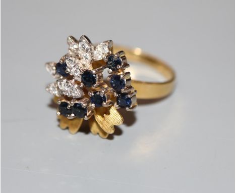 A modern 18ct gold, sapphire and diamond raised cluster dress ring, size N, gross 7.4 grams.CONDITION: Minor scratches to the