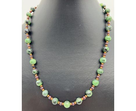 An 18" costume jewellery necklace of Ruby in Zoisite, garnet and gold tone spherical beads. With a gold tone S shaped clasp. 