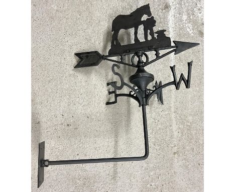 A black painted cast metal weathervane with Blacksmith shaped finial. With wall mounting bracket. Approx. 58cm tall. 
