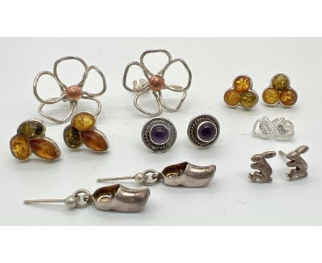 7 pairs of silver and white metal stud and drop style earrings for pierced ears. To include amber set studs, Dutch clog drop 