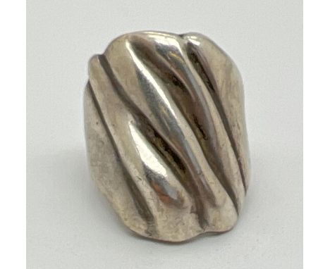 A contemporary design large silver dress ring. Rough grooved detail to top of ring. Worn 925 mark to inside of ring. Size O, 