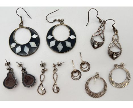 6 pairs of drop style silver and white metal earrings. To include geode, treble clef set with a single clear stone and Celtic